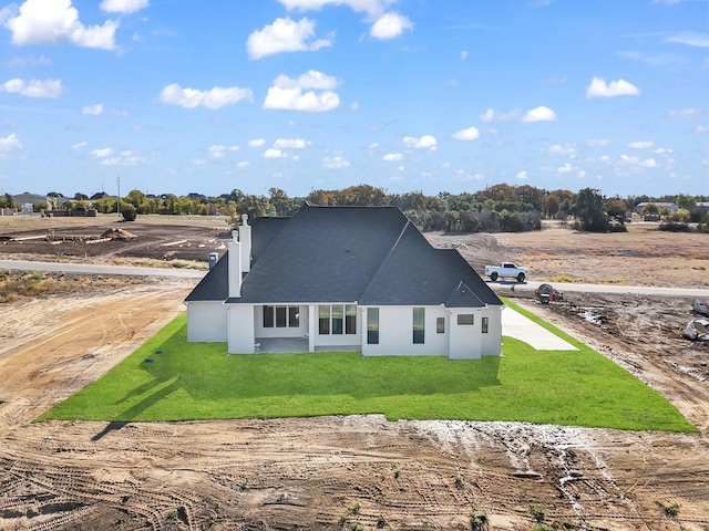 rear view of house featuring a lawn