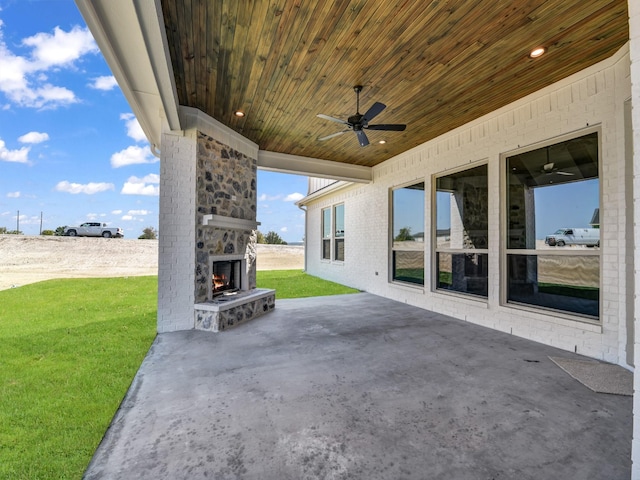 view of patio featuring an outdoor stone fireplace and ceiling fan