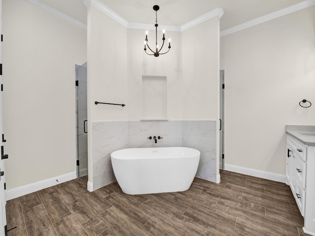 bathroom with vanity, an inviting chandelier, ornamental molding, tile walls, and wood-type flooring