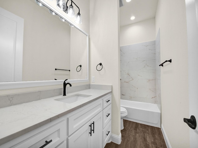 full bathroom with vanity, wood-type flooring, tiled shower / bath combo, and toilet