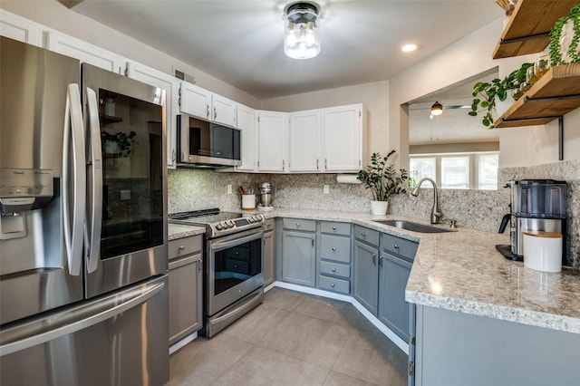 kitchen with white cabinetry, sink, backsplash, light tile patterned floors, and appliances with stainless steel finishes