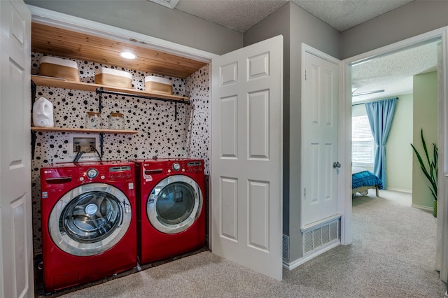 laundry area with light carpet, independent washer and dryer, and a textured ceiling