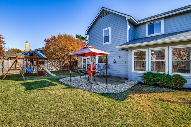 back of property with a lawn, a patio area, and a playground