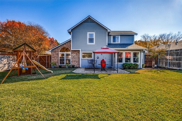 back of house with a lawn, a playground, and a patio