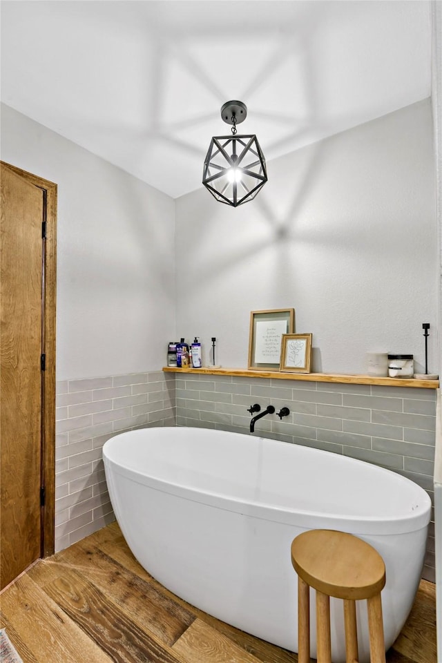 bathroom with tile walls and a tub