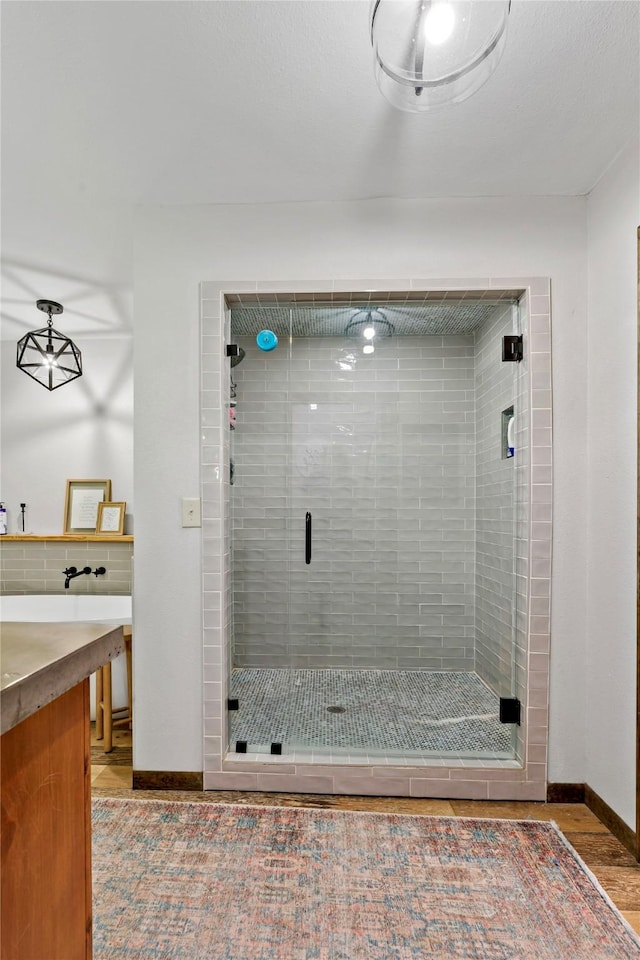 bathroom with vanity, backsplash, hardwood / wood-style flooring, and walk in shower