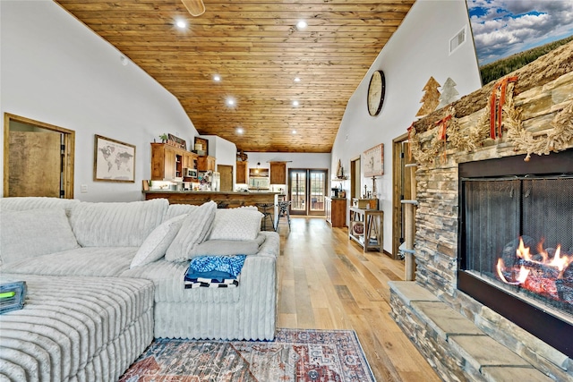 living room featuring a fireplace, light hardwood / wood-style floors, high vaulted ceiling, and wooden ceiling