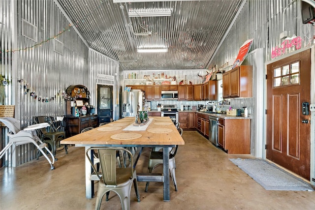 dining space featuring sink and a towering ceiling