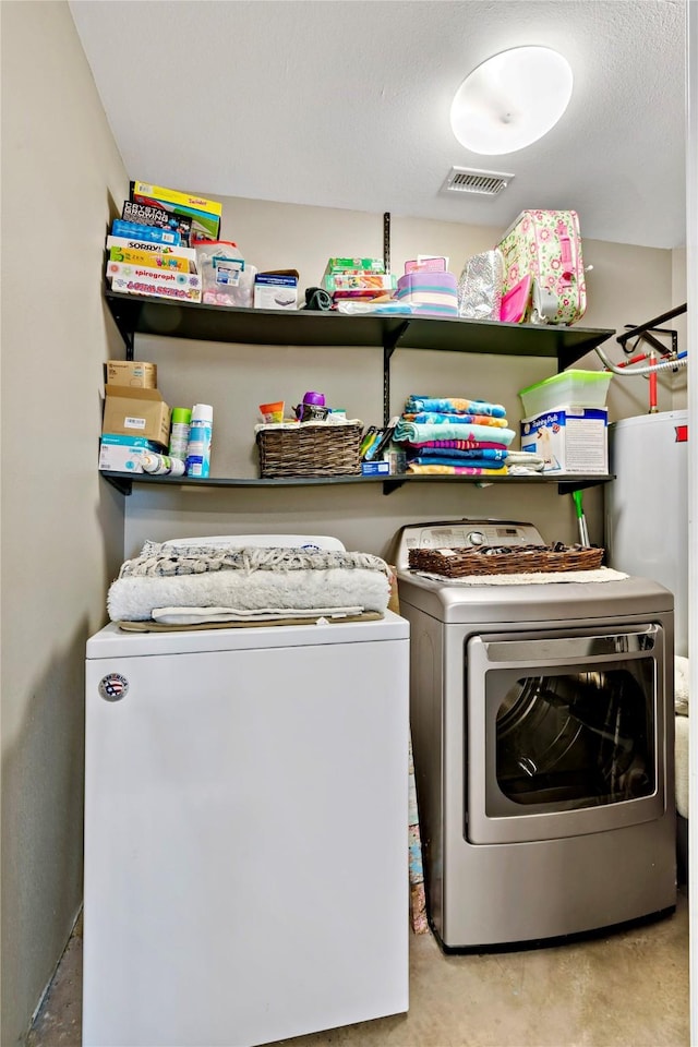 laundry room with water heater and washing machine and dryer