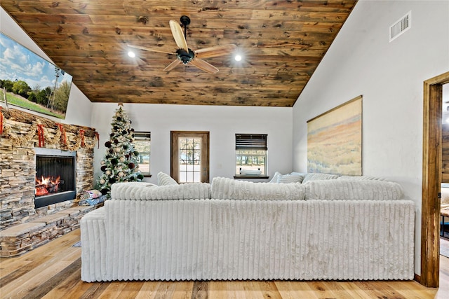 living room with wood-type flooring, a stone fireplace, high vaulted ceiling, and wood ceiling