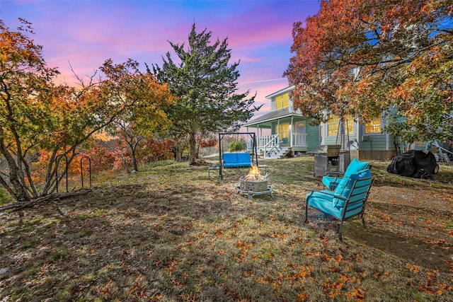 yard at dusk featuring an outdoor fire pit