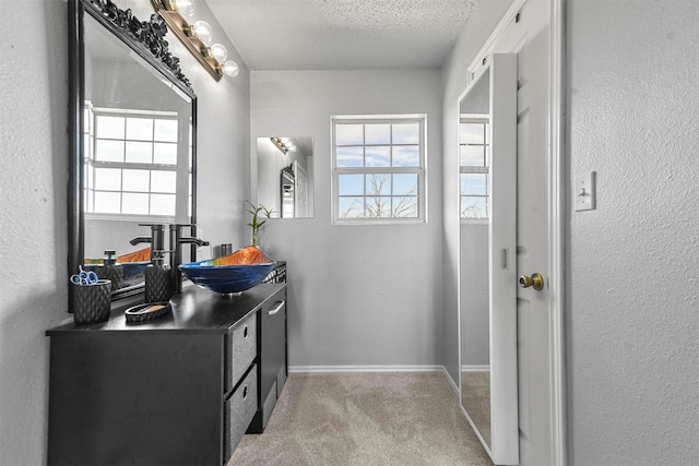 bathroom featuring a wealth of natural light, vanity, and a textured ceiling