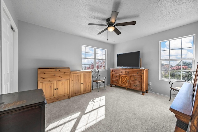 carpeted bedroom with a textured ceiling, a closet, and ceiling fan