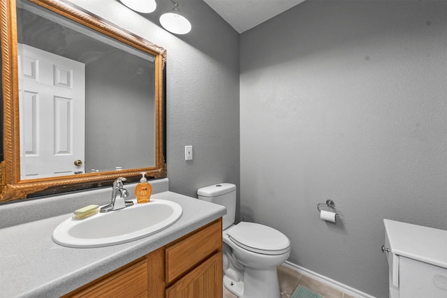 bathroom featuring tile patterned floors, vanity, and toilet