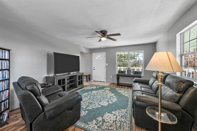 living room with hardwood / wood-style floors, a textured ceiling, ceiling fan, and a healthy amount of sunlight