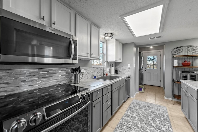 kitchen featuring sink, stainless steel appliances, a wealth of natural light, and tasteful backsplash