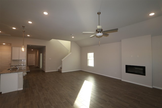 unfurnished living room with ceiling fan, dark hardwood / wood-style flooring, lofted ceiling, and sink