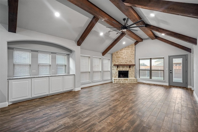 unfurnished living room with dark hardwood / wood-style floors, lofted ceiling with beams, a fireplace, and ceiling fan