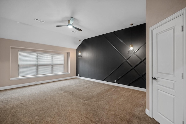 carpeted spare room featuring ceiling fan and vaulted ceiling