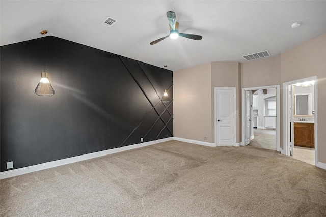 unfurnished bedroom featuring carpet flooring, ensuite bath, ceiling fan, and vaulted ceiling