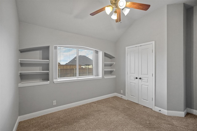 unfurnished bedroom with carpet, a closet, vaulted ceiling, and ceiling fan