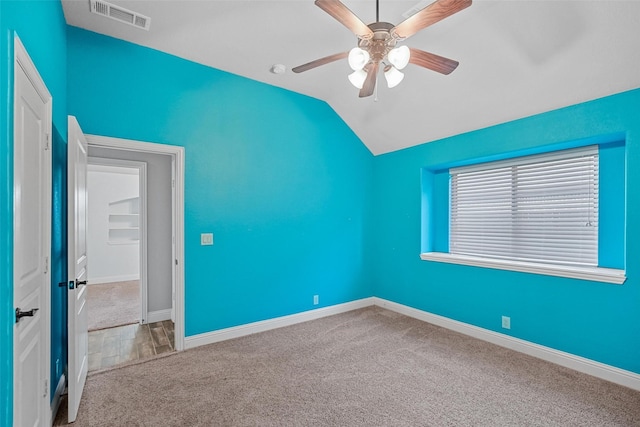 unfurnished room featuring carpet floors, vaulted ceiling, and ceiling fan