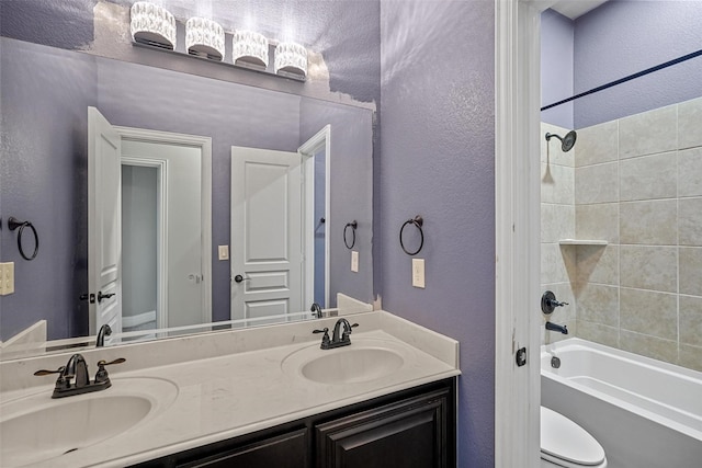 full bathroom featuring vanity, toilet, and tiled shower / bath