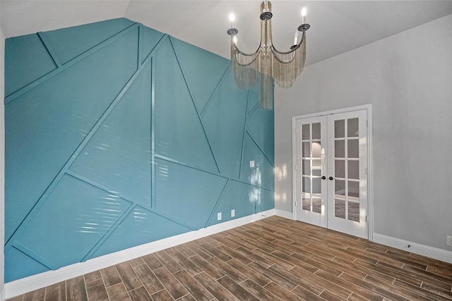 spare room with vaulted ceiling, a notable chandelier, and french doors