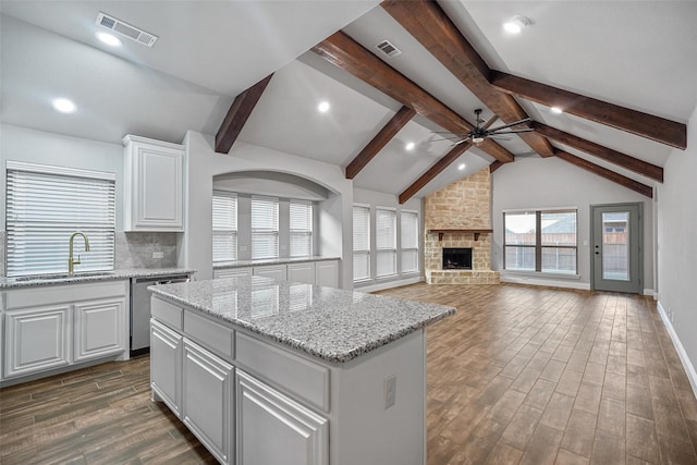 kitchen featuring sink, dishwasher, white cabinets, a center island, and dark hardwood / wood-style floors