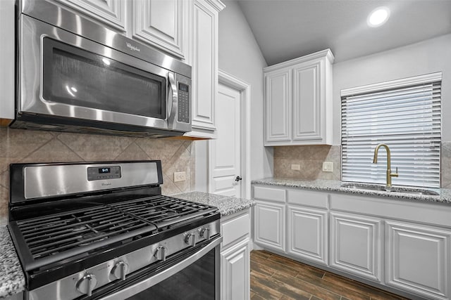 kitchen featuring white cabinets, appliances with stainless steel finishes, dark wood-type flooring, and sink