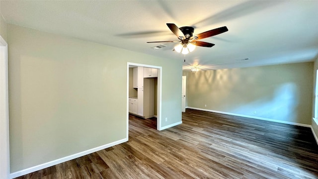 spare room featuring dark wood-type flooring and ceiling fan