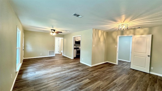 spare room featuring hardwood / wood-style floors and ceiling fan with notable chandelier