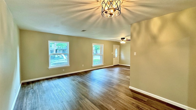 empty room with ceiling fan and dark hardwood / wood-style flooring