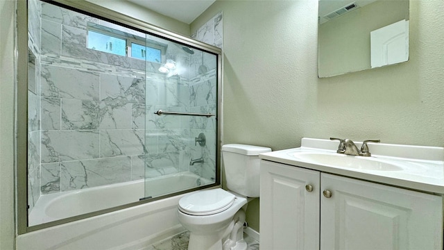 full bathroom featuring shower / bath combination with glass door, vanity, and toilet