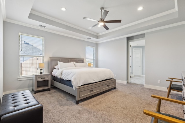 carpeted bedroom featuring a raised ceiling, ceiling fan, and ornamental molding