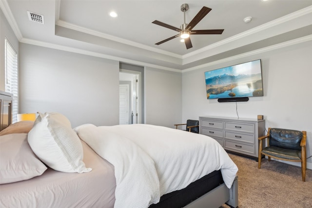 carpeted bedroom featuring ceiling fan, crown molding, and a tray ceiling