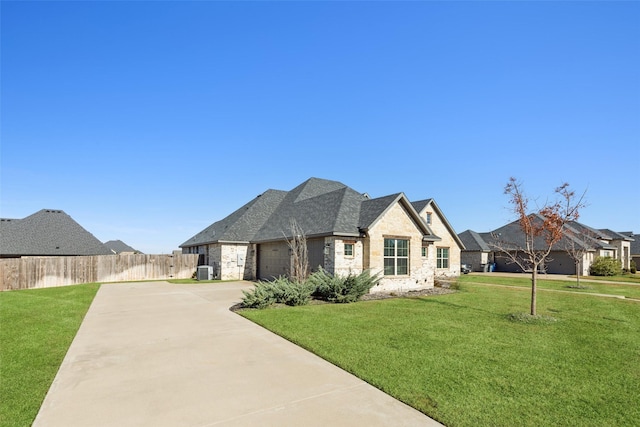 french country style house with a garage, a front lawn, and central air condition unit