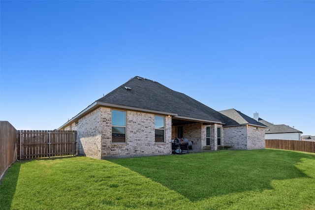 rear view of house featuring a lawn