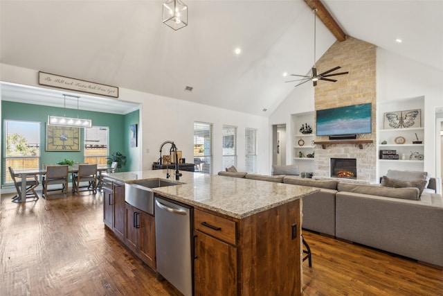 kitchen with a center island with sink, stainless steel dishwasher, a wealth of natural light, and sink