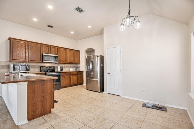 kitchen with sink, hanging light fixtures, tasteful backsplash, a kitchen bar, and stainless steel appliances