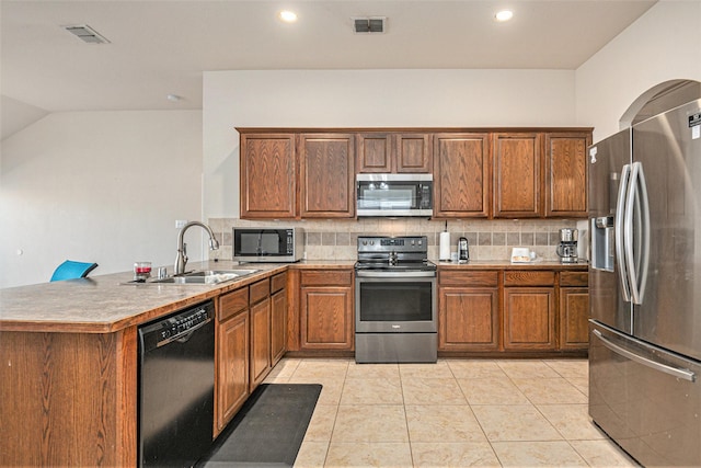 kitchen featuring sink, decorative backsplash, light tile patterned floors, kitchen peninsula, and stainless steel appliances