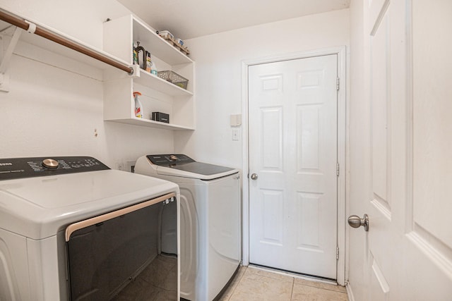 clothes washing area with washing machine and dryer and light tile patterned floors