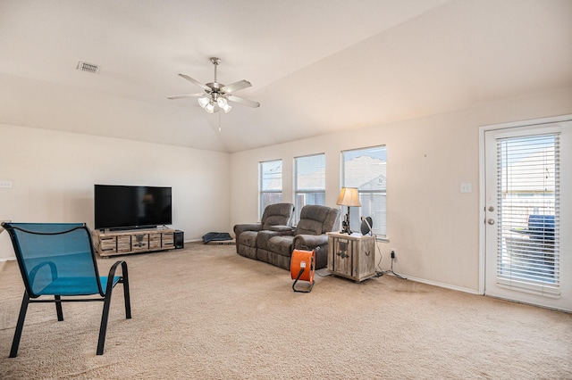 carpeted living room with ceiling fan, a healthy amount of sunlight, and vaulted ceiling