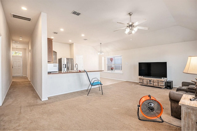 carpeted living room with ceiling fan with notable chandelier, lofted ceiling, and sink