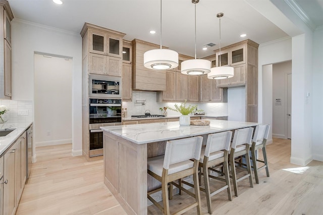 kitchen featuring light hardwood / wood-style floors, a kitchen island, tasteful backsplash, and light stone counters