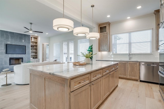 kitchen featuring light hardwood / wood-style flooring, a kitchen island, plenty of natural light, and stainless steel dishwasher