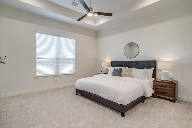 carpeted bedroom featuring a tray ceiling, ceiling fan, and ornamental molding