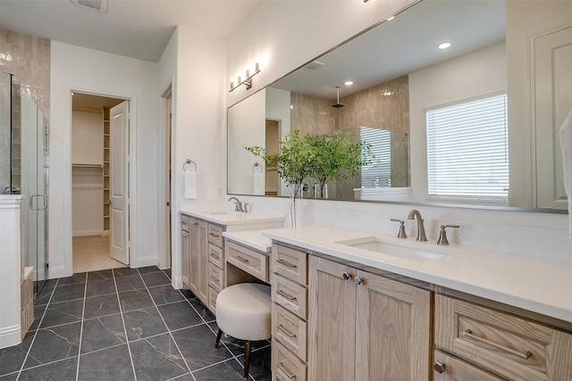 bathroom with tile patterned flooring, vanity, and a shower with door