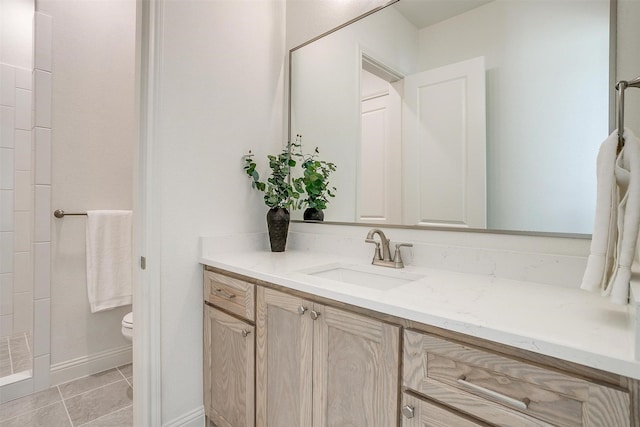 bathroom featuring tile patterned flooring, vanity, toilet, and walk in shower