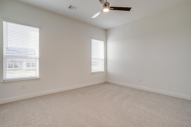 empty room with carpet, ceiling fan, and a healthy amount of sunlight